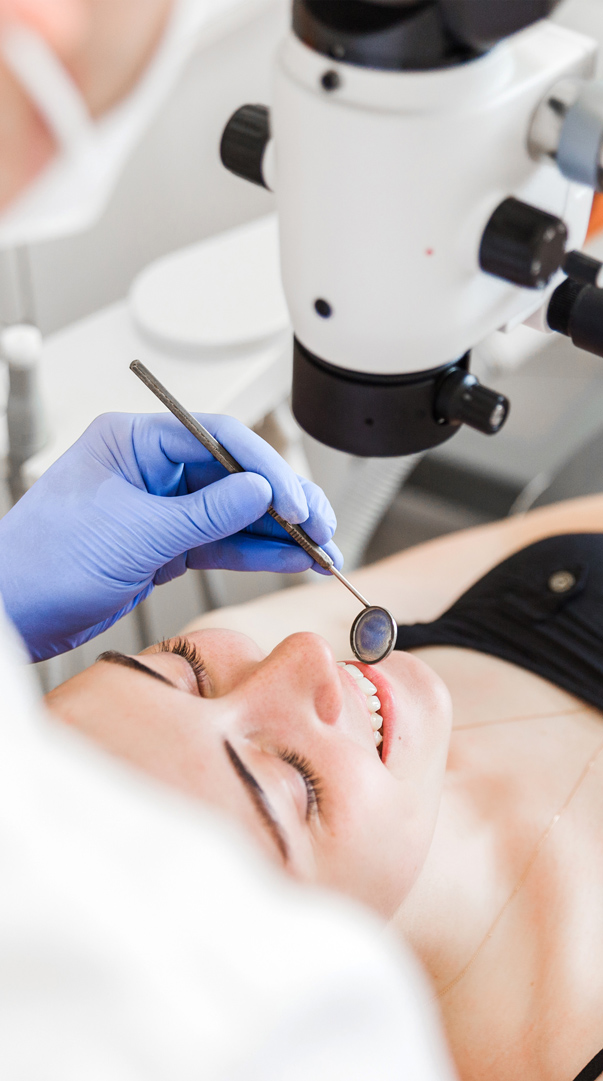 Dentist wearing blue gloves and preparing tools for a patient in a dental bib in Des Moines IA