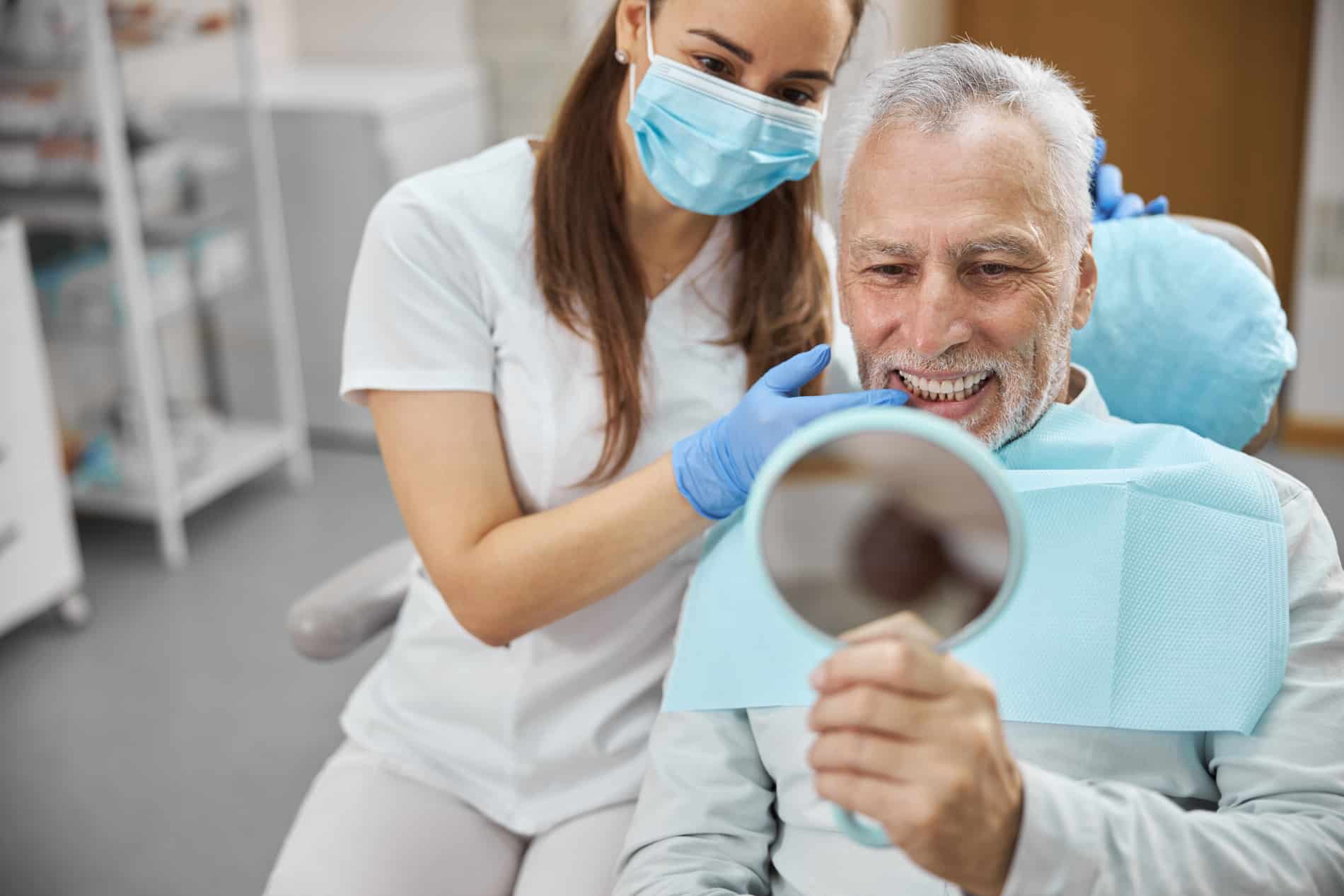 Man looking at his new dental implants with Dr. Cholewa in Des Moines IA