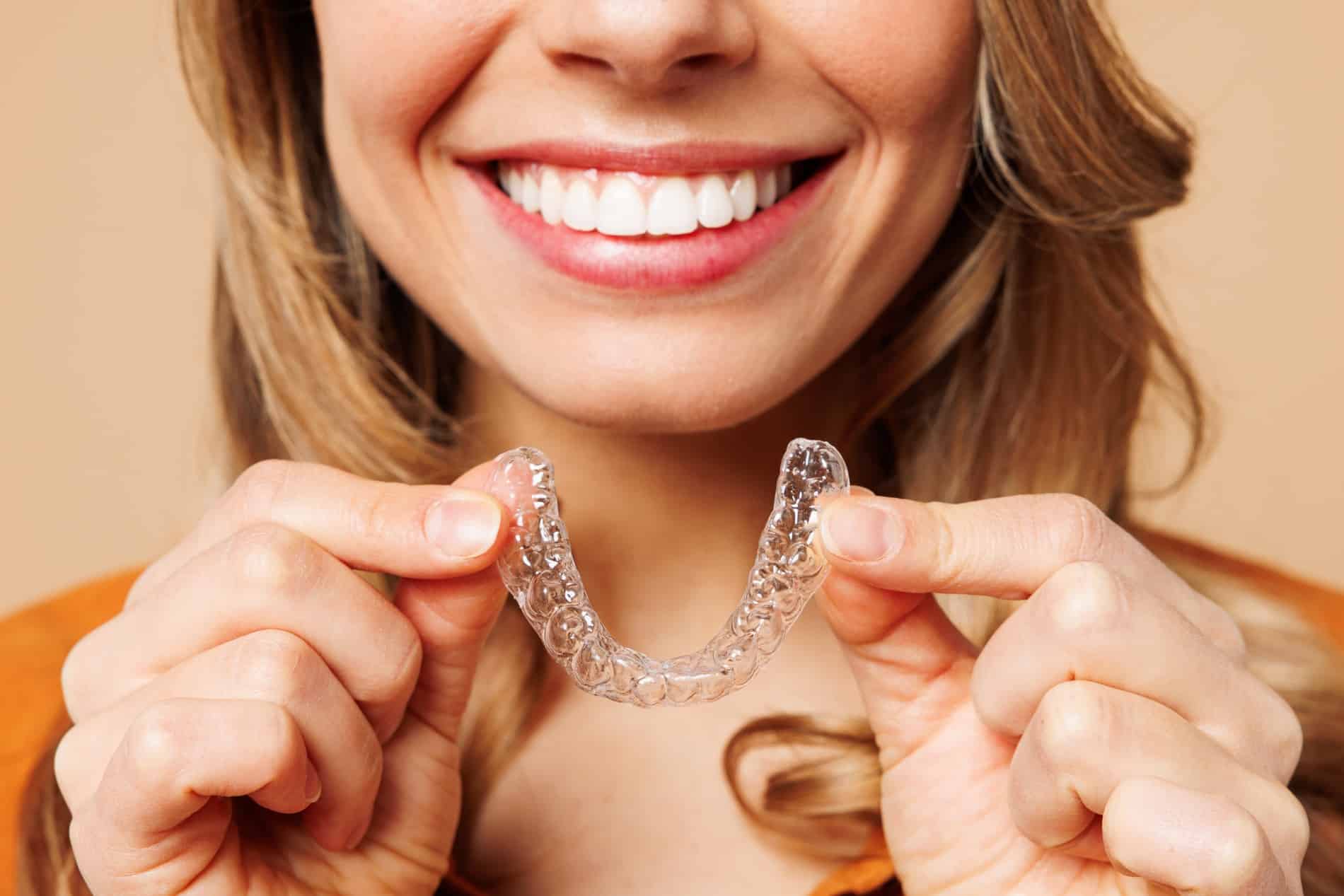 Woman showing of her tranformed smile after dental aligners in Des Moines IA