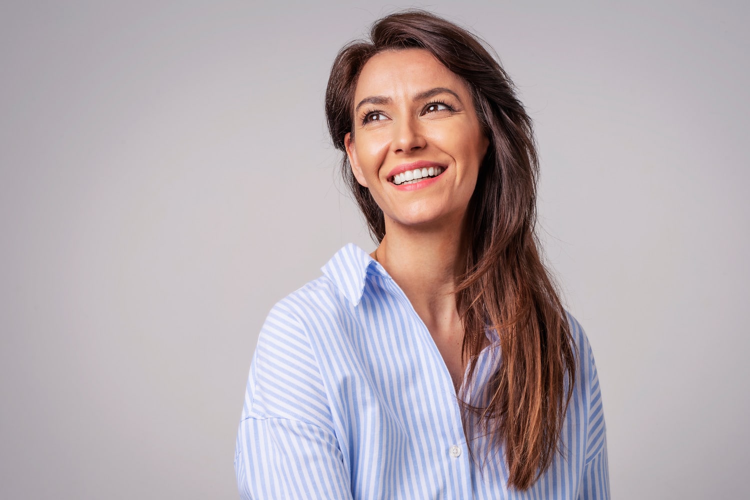 Woman smiling with healthy teeth after same-day crowns in Des Moines
