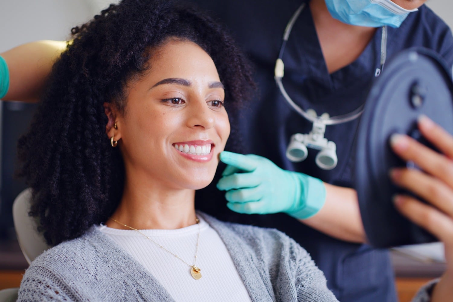 Woman looking at her beautiful teeth after a fluoride treatment in Des Moines IA